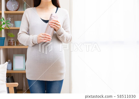 Pregnant woman with a water bottle 58511030