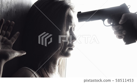 man use handgun aim on women's heads for intimidate. stop domestic violence against women campaign. reform gun control concept 58511453
