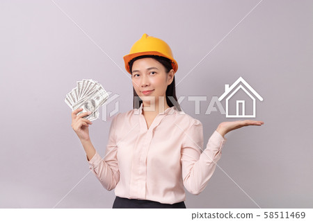 loans for real estate concept, woman with yellow helmet holding banknote money in hand and white logo home icon in another hand loans for real estate concept, woman with yellow helmet holding banknote money in hand and white logo home icon in another hand 58511469