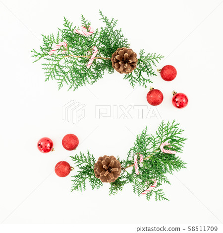 Christmas composition of pine branches and red balls decoration with candy cane on white. Flat lay Christmas composition of pine branches and red balls decoration with candy cane on white. Flat lay 58511709