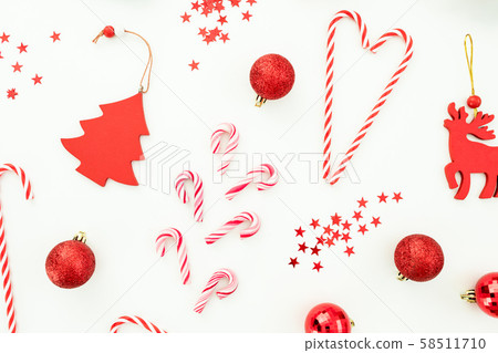 Christmas or New Year composition. Red toys, candy canes and confetti on white background. Flat lay Christmas or New Year composition. Red toys, candy canes and confetti on white background. Flat lay 58511710