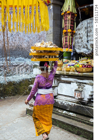 Indonesia Bali, Sept 20 2019, Woman with fruit basket on her head for offering in temple 58511734