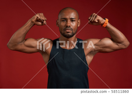 I am strong and healthy. Portrait of handsome afro american man showing his biceps and looking at 58511860