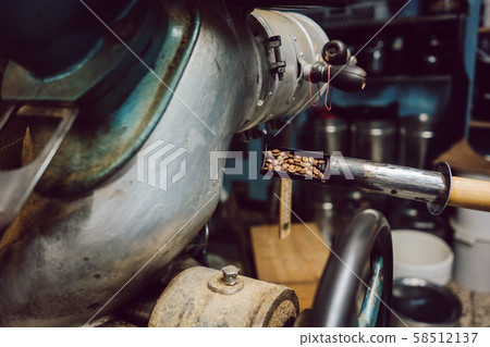 Sample being taken out of coffee roaster 58512137