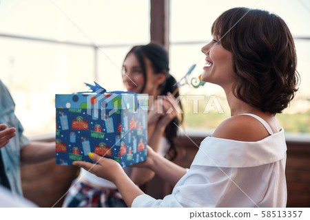 Birthday surprise Young smiling woman is holding a gift box while standing on the roof around 58513357