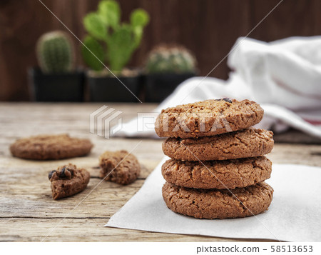 stack of chocolate chip cookies on white napkin paper on wooden table decorate with cactus at background stack of chocolate chip cookies on white napkin paper on wooden table decorate with cactus at background 58513653