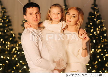 Little girl on holliday with mom and dad. Happy family on Christmas Little girl on holliday with mom and dad. Happy family on Christmas 58513863