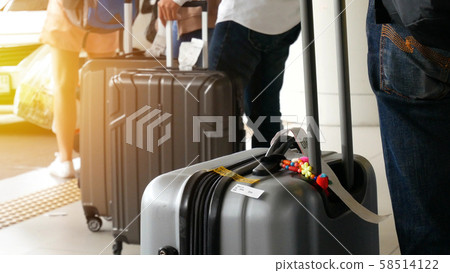 airport taxi. passenger with big roller luggage standing on the line waiting for taxi queue at taxi parking lot at airport arrival terminal