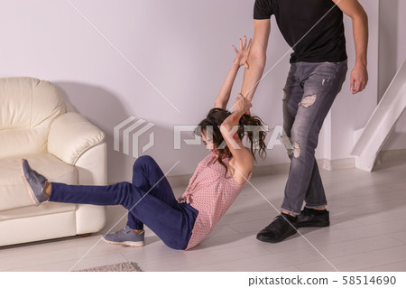 Domestic violence, abuse and victim concept - aggressive man dragging helpless woman by hair Domestic violence, abuse and victim concept - aggressive man dragging helpless woman by hair 58514690