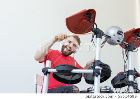 People, music and hobby concept - Happy man who spends his free time playing drums 58514699