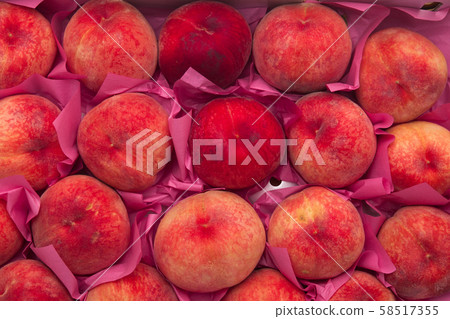 Pile of ripe peaches on a box  58517355