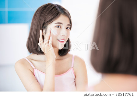 woman apply cream on face 58517761