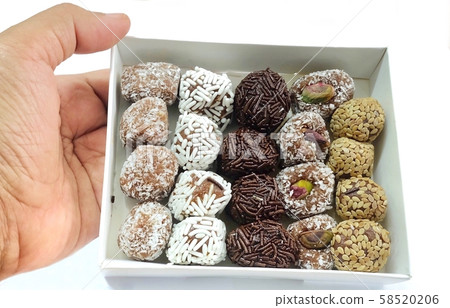 Hand Holding Box of Round Chocolate Candies Hand Holding Box of Round Chocolate Candies 58520206
