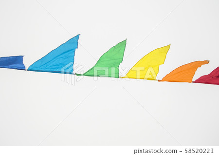 Colorful triangles flags ornament for carnival and holiday hanging on a rope and fluttering in the 58520221