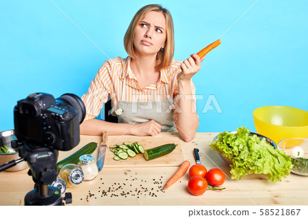 Female nutrition expert looks aside, thinks what to cook out of raw vegetable Female nutrition expert looks aside, thinks what to cook out of raw vegetable 58521867