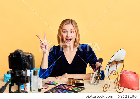 Popular lifestyle female blogger makes peace sign, saying hello to followers 58522196