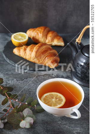 Lemon tea, two fresh croissants and teapot 58522705