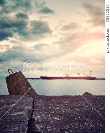 Concrete breakwater with a LNG tanker in distance Concrete breakwater with a LNG tanker in distance 58522856