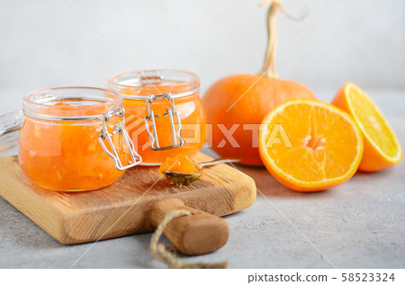 Homemade pumpkin and orange confiture in a jars on a gray concrete background. 58523324