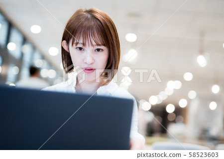 一個20多歲的女人在時尚的辦公室用筆記本電腦工作 一個20多歲的女人在時尚的辦公室用筆記本電腦工作 58523603