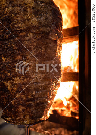 Close up shot of stacked meat roasting to be used in preparation of traditional Greek dish gyros or 58523800