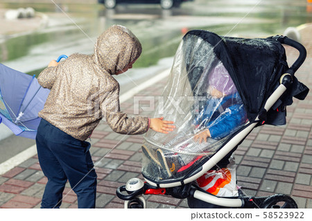 Two cute caucasian siblings in casual sport clothes having fun enjoy walking during rain in autumn Two cute caucasian siblings in casual sport clothes having fun enjoy walking during rain in autumn 58523922