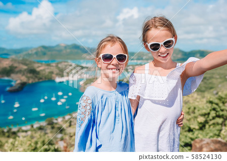 Adorable little kids enjoying the view of picturesque English Harbour at Antigua in caribbean sea Adorable little kids enjoying the view of picturesque English Harbour at Antigua in caribbean sea 58524130