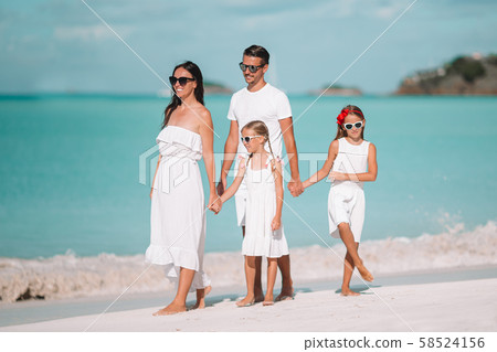 Happy beautiful family of four on white beach Happy beautiful family of four on white beach 58524156