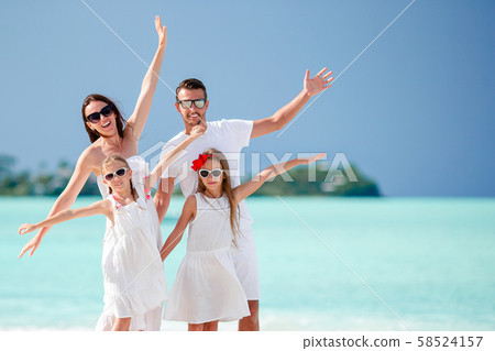 Happy beautiful family of four on the beach Happy beautiful family of four on the beach 58524157