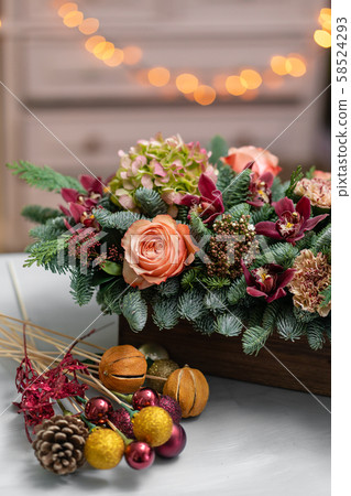Beautiful festive arrangement of fresh spruce with ball toys in a rustic wooden box. Christmas mood 58524293