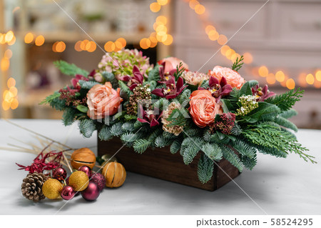 Beautiful festive arrangement of fresh spruce with ball toys in a rustic wooden box. Christmas mood 58524295