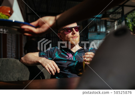 Man in sunglasses drinks lemonade and awaits his lunch 58525876