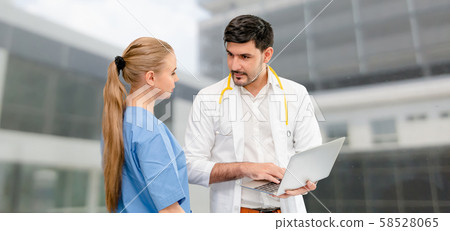 Doctors at hospital working with another doctor. 58528065