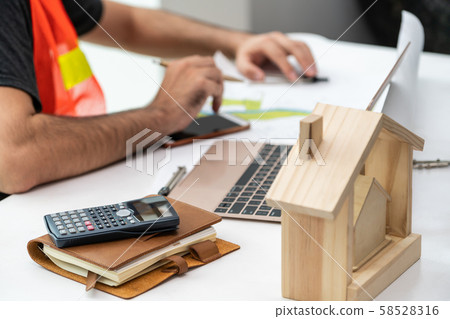 Young man architect or engineer working at desk. Young man architect or engineer working at desk. 58528316