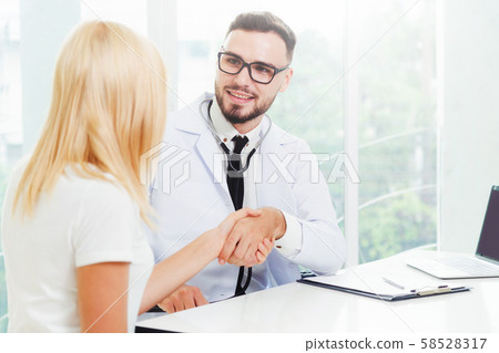 Male Doctor and Female Patient in Hospital Office 58528317