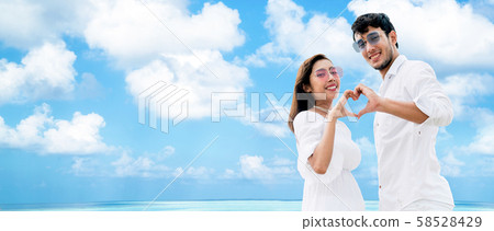 Happy couple making heart sign gesture with hands. Happy couple making heart sign gesture with hands. 58528429