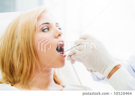 Young dentist examining patient in dental clinic. Young dentist examining patient in dental clinic. 58528464