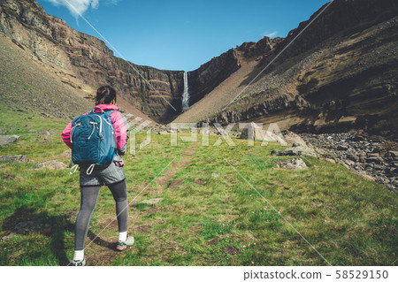 Traveler hiking at Hengifoss Waterfall, Iceland. 58529150