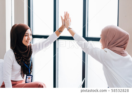 Ethnic Muslim businesswomen giving high five 58532828