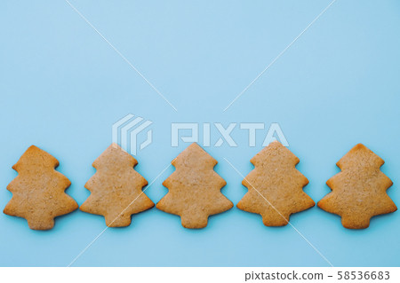 Holiday cookies in the shape of Christmas tree on light blue background. Space for text. 58536683