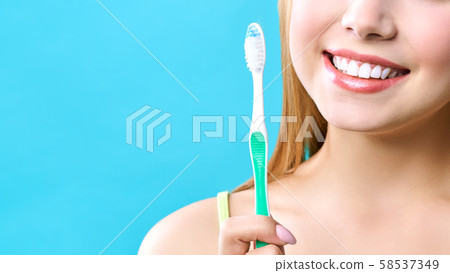Young beautiful woman is engaged in cleaning teeth. Beautiful smile healthy white teeth. A girl Young beautiful woman is engaged in cleaning teeth. Beautiful smile healthy white teeth. A girl 58537349