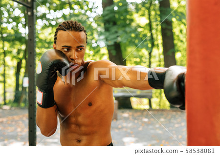 Exhausted kickboxer leaning on a punching bag Exhausted kickboxer leaning on a punching bag 58538081