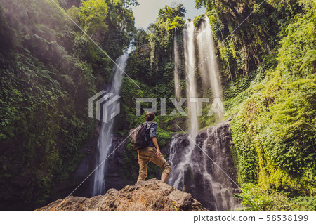 Man in turquoise dress at the Sekumpul waterfalls in jungles on Bali island, Indonesia. Bali Travel Man in turquoise dress at the Sekumpul waterfalls in jungles on Bali island, Indonesia. Bali Travel 58538199