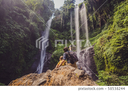 Dad and son at the Sekumpul waterfalls in jungles on Bali island, Indonesia. Bali Travel Concept Dad and son at the Sekumpul waterfalls in jungles on Bali island, Indonesia. Bali Travel Concept 58538244