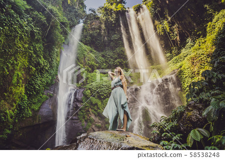 Woman in turquoise dress at the Sekumpul waterfalls in jungles on Bali island, Indonesia. Bali Woman in turquoise dress at the Sekumpul waterfalls in jungles on Bali island, Indonesia. Bali 58538248