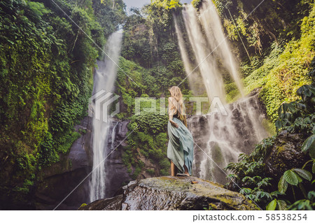 Woman in turquoise dress at the Sekumpul waterfalls in jungles on Bali island, Indonesia. Bali Woman in turquoise dress at the Sekumpul waterfalls in jungles on Bali island, Indonesia. Bali 58538254