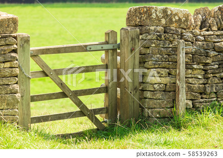 Rustic gate in drystone wall in Bibury England UK. 58539263