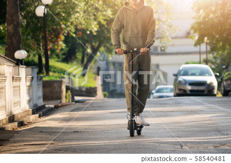 A man with electric scooter on the street 58540481
