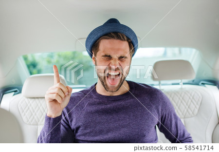 Cheerful man with hat sitting in car, having fun. Cheerful man with hat sitting in car, having fun. 58541714