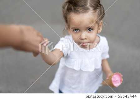 Little caucasian girl 3 years old eats ice cream Little caucasian girl 3 years old eats ice cream 58545444